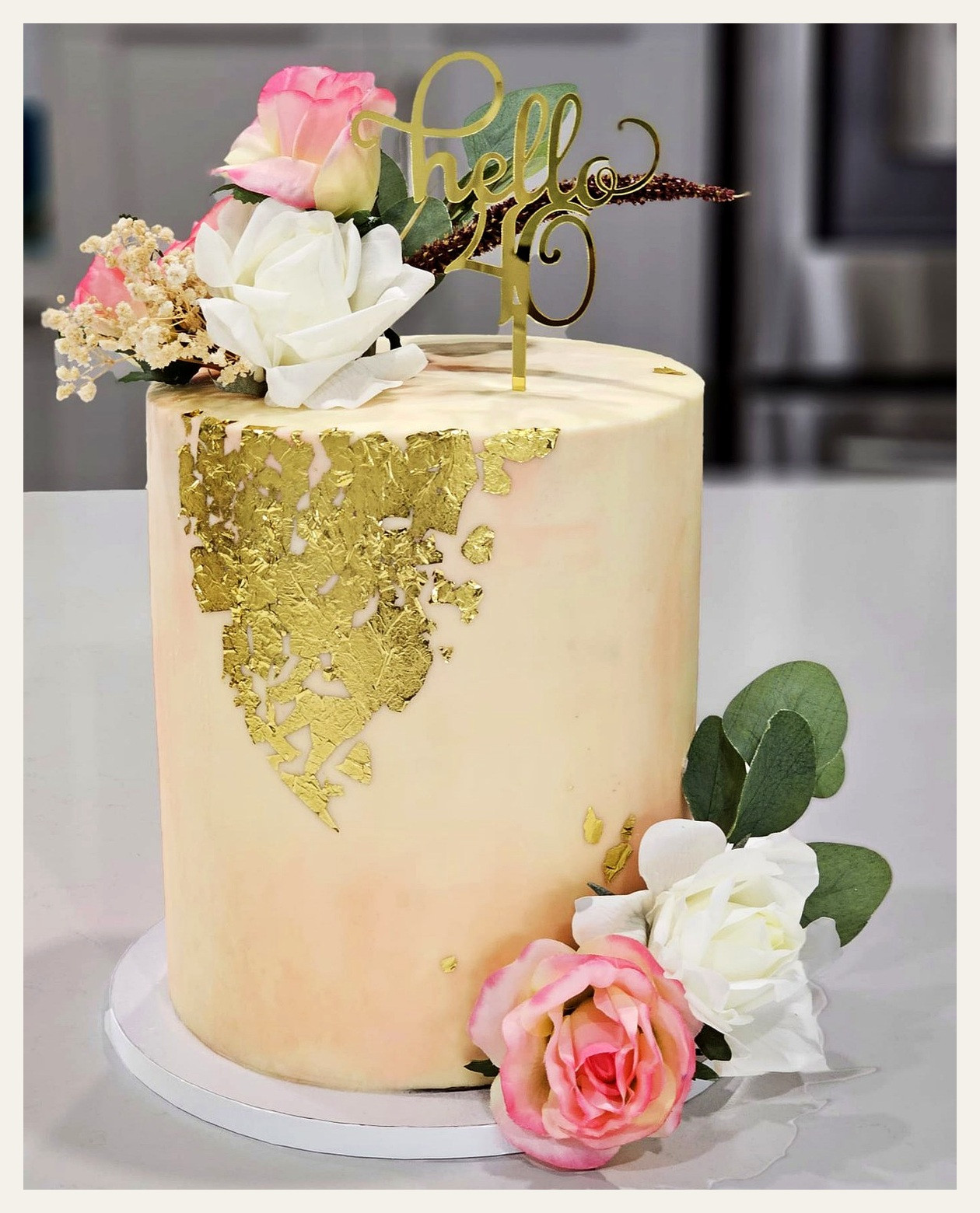 Elegant Hello 40 birthday cake with pink flowers and gold leaf