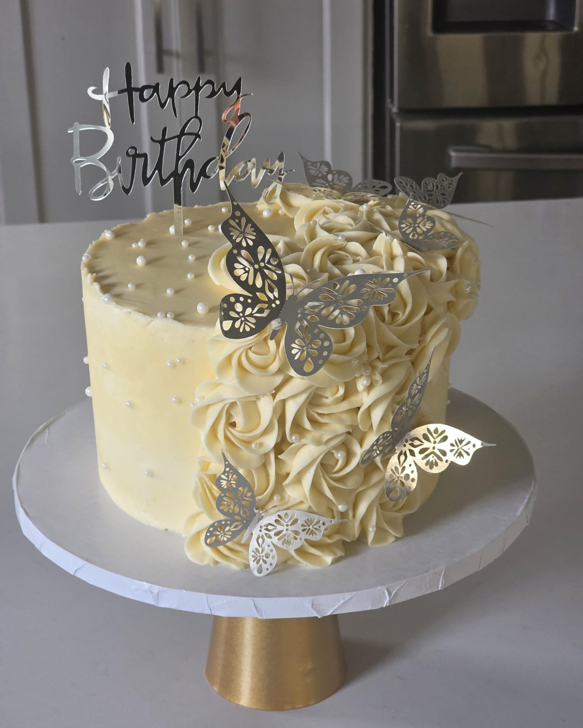 Ivory birthday cake decorated with delicate butterfly details
