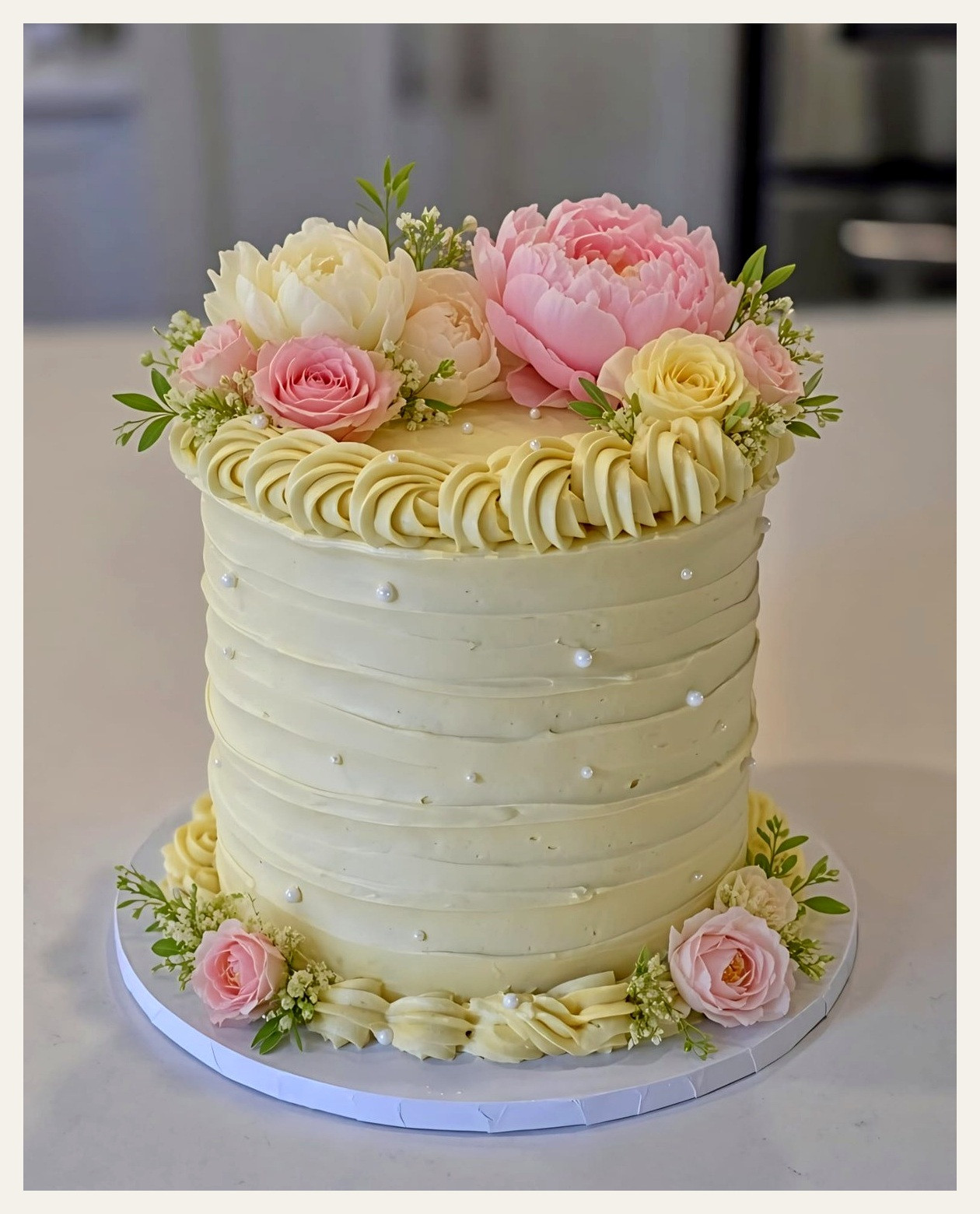 Elegant three-tier peach and ivory floral cake