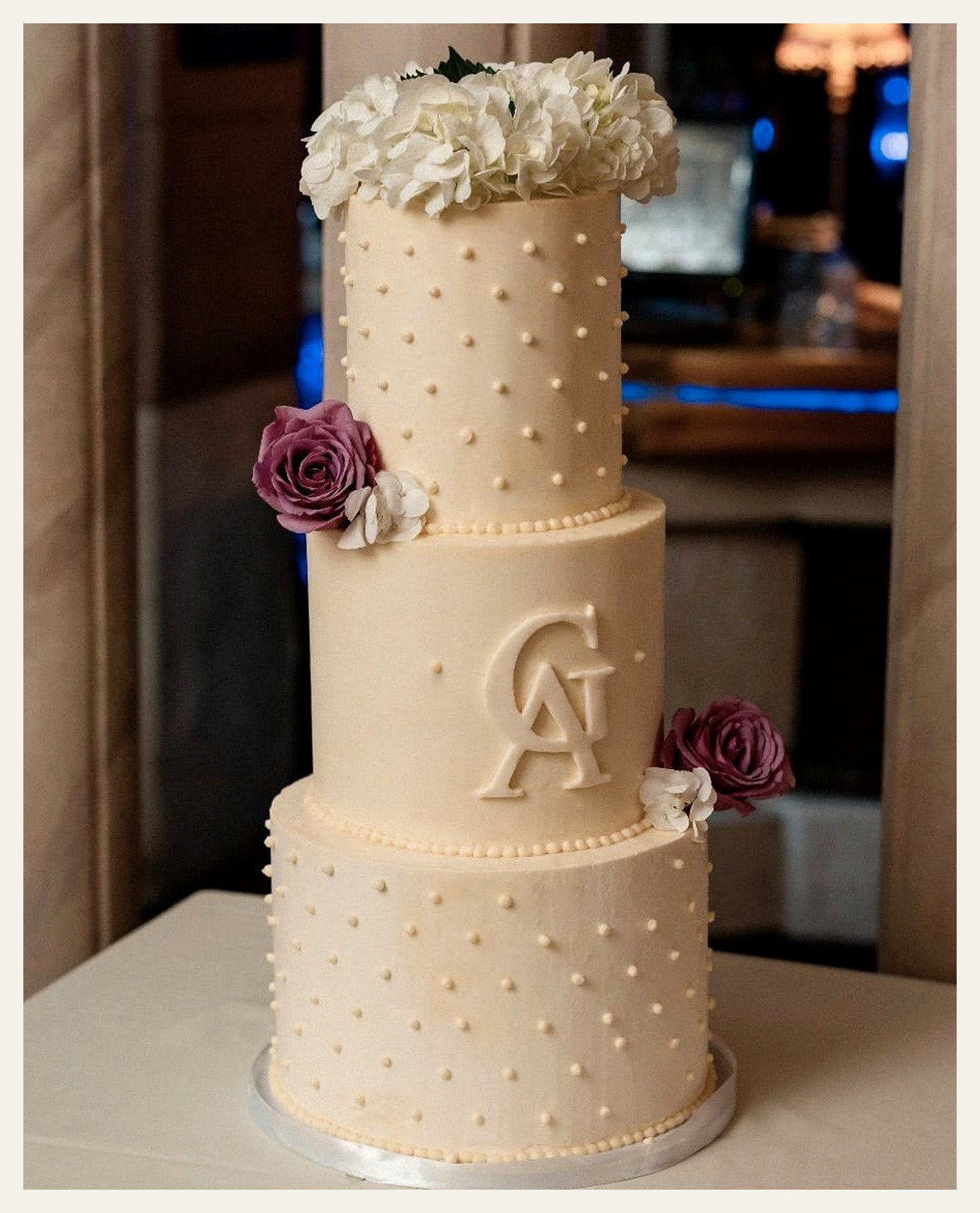 Elegant three-tier floral wedding cake displayed at a wedding reception